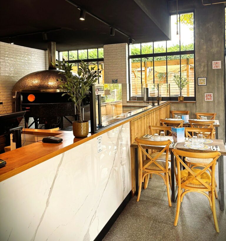 Photo du four à pizza et des tables chez Pizza Paolo