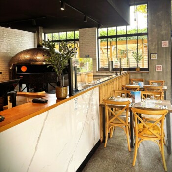 Photo du four à pizza et des tables chez Pizza Paolo